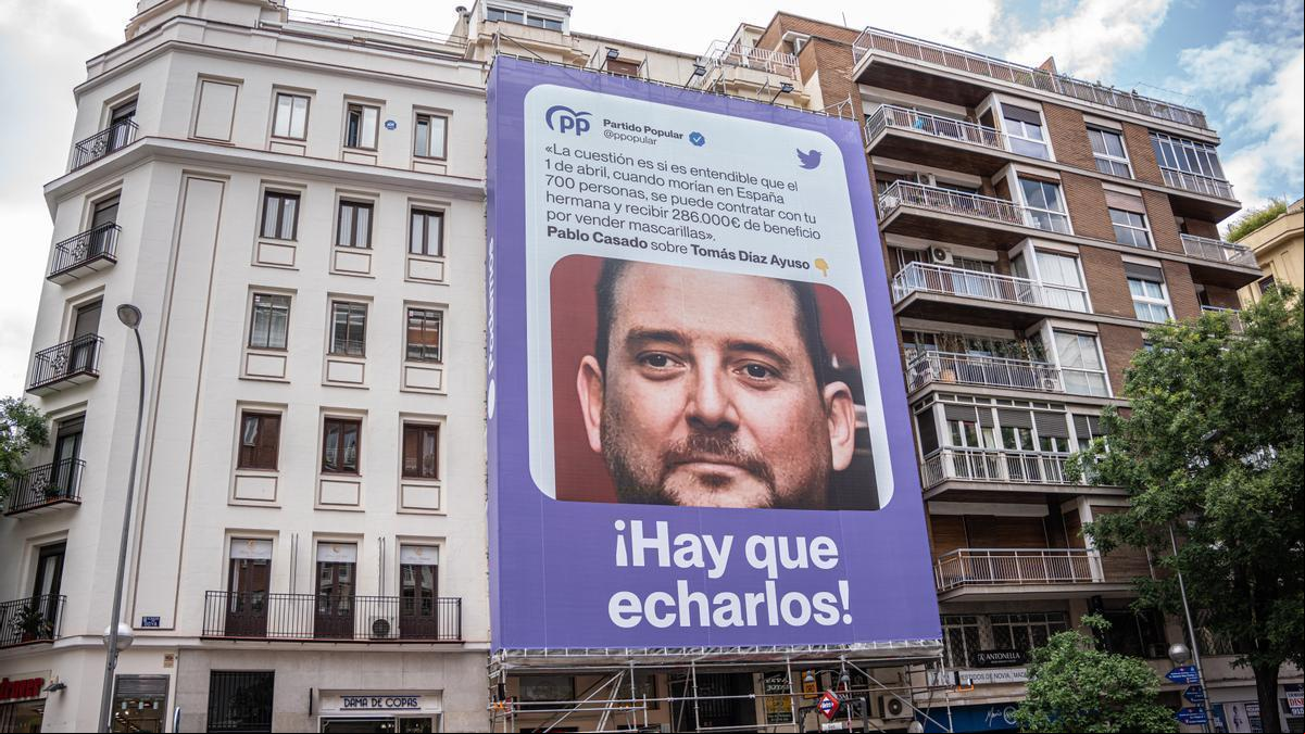 Podemos coloca una lona con la foto del hermano de Ayuso junto a una cita de Pablo Casado